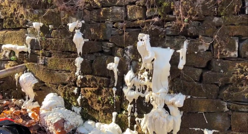 image of polyurethane filling voids in between the stones that make up the dam during dam sealing and stabilization project